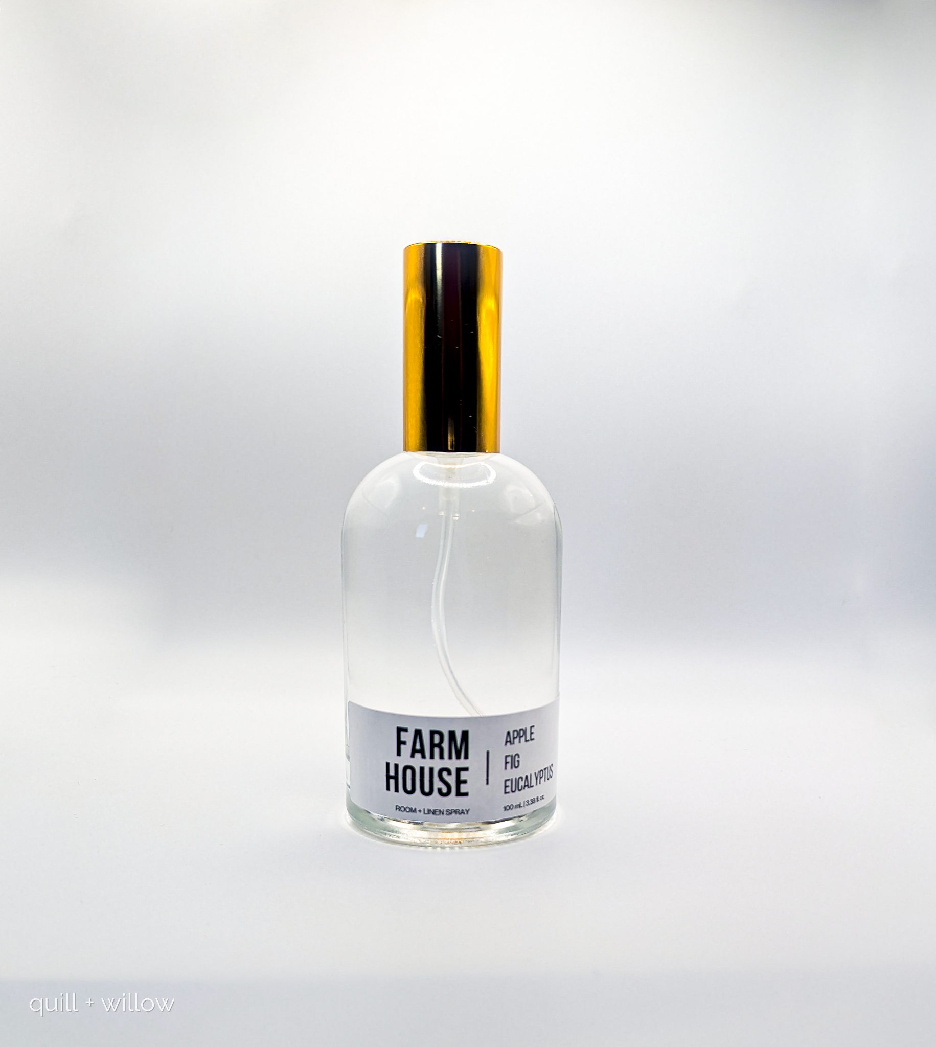 Clear glass bottle with black and gold cap on a white background