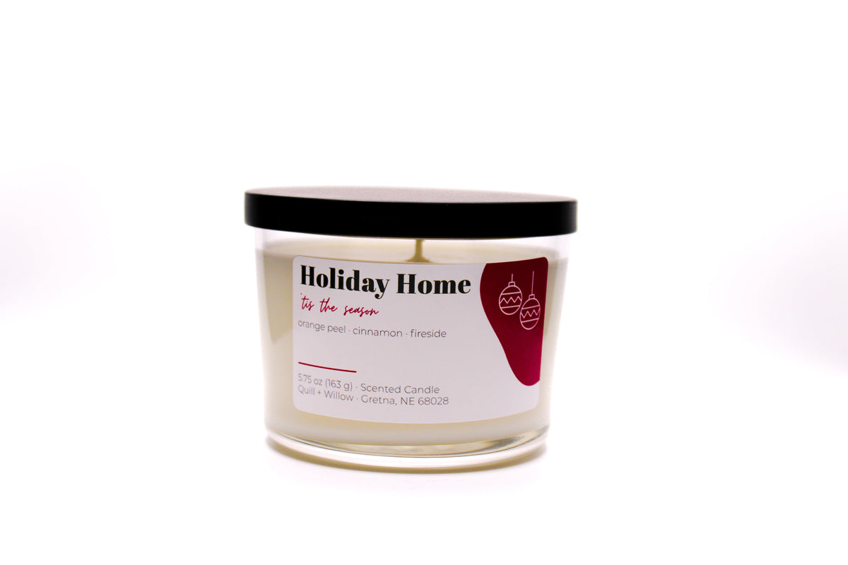 A glass jar candle labeled 'Holiday Home' on a plain white background.