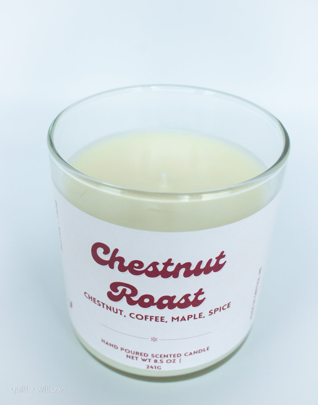 Candle in a glass jar labeled 'Chestnut Roast' on a white background