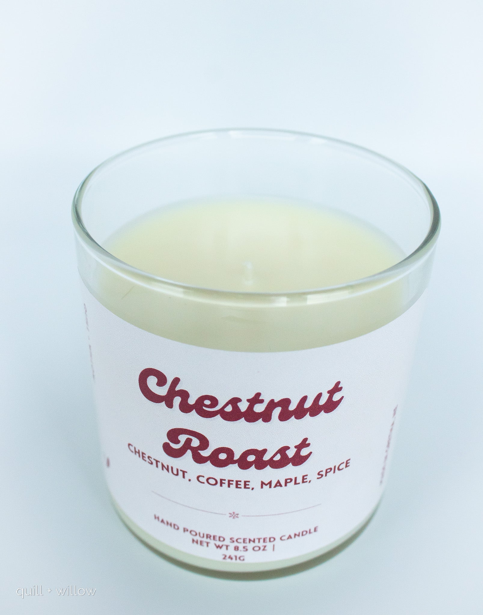 Candle in a glass jar labeled 'Chestnut Roast' on a white background