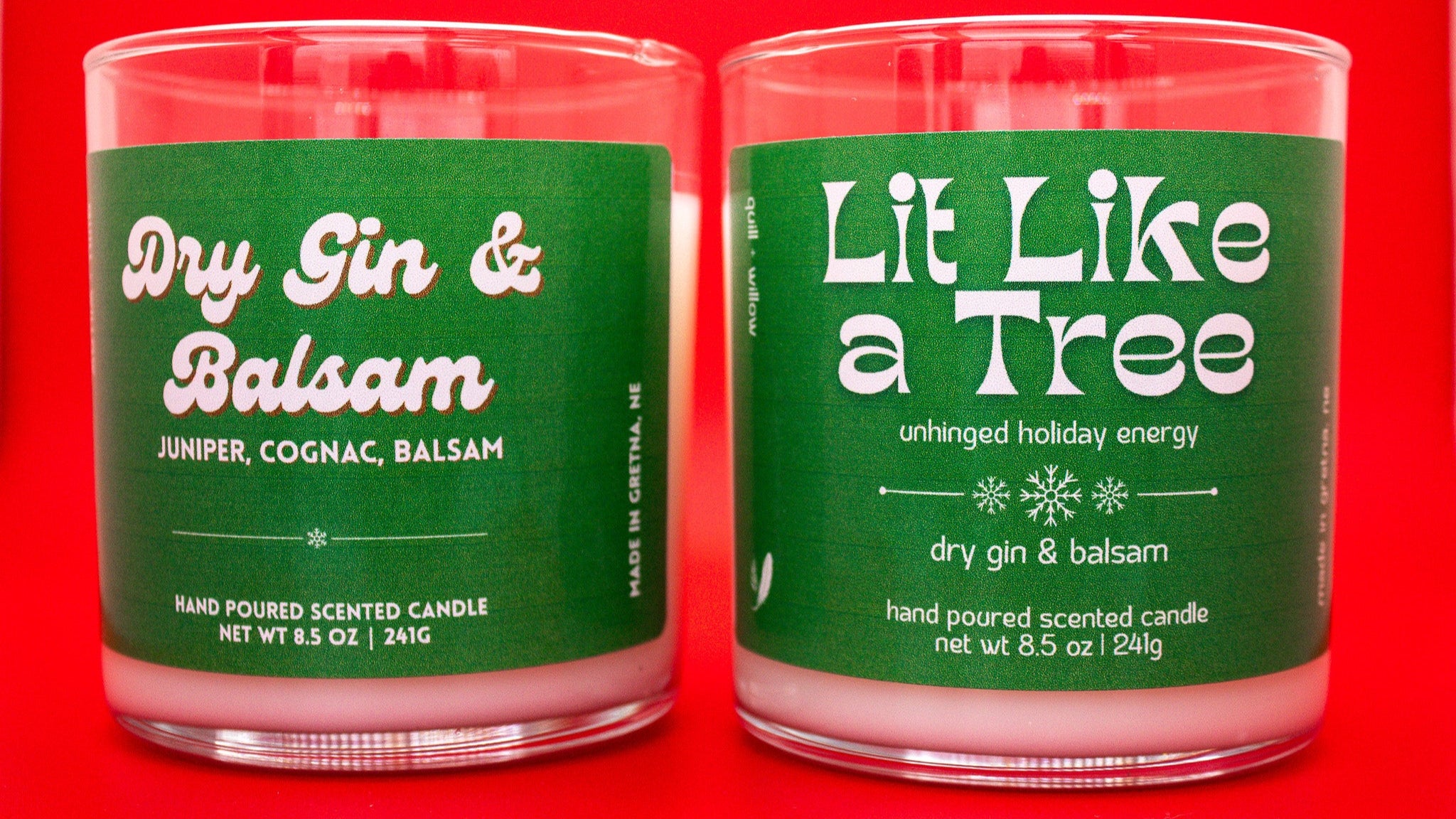 Two green candles with labels on a red background