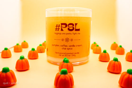 Scented candle labeled '#PSL' with decorative pumpkins on a yellow background