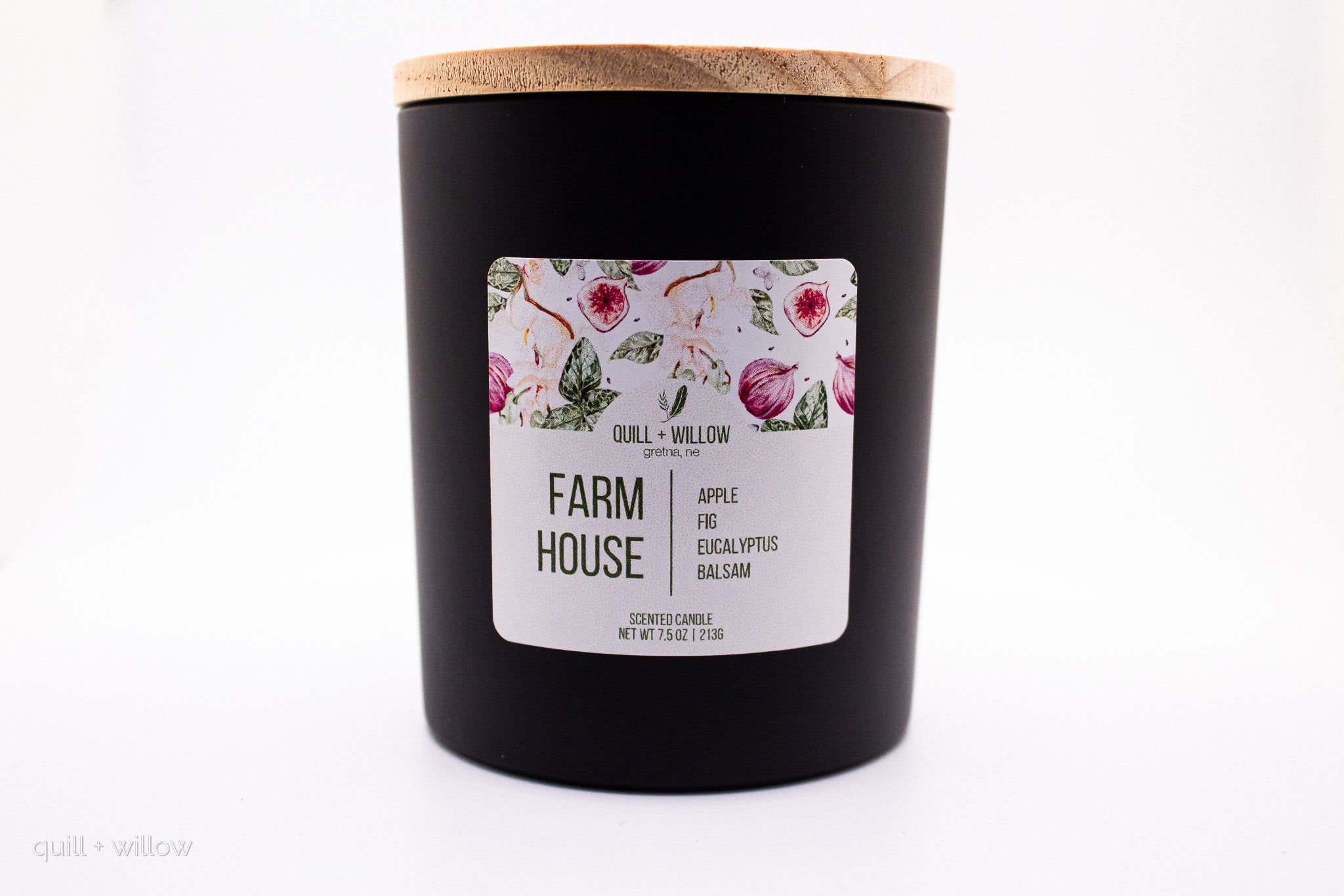 Black candle with a floral label on a white background