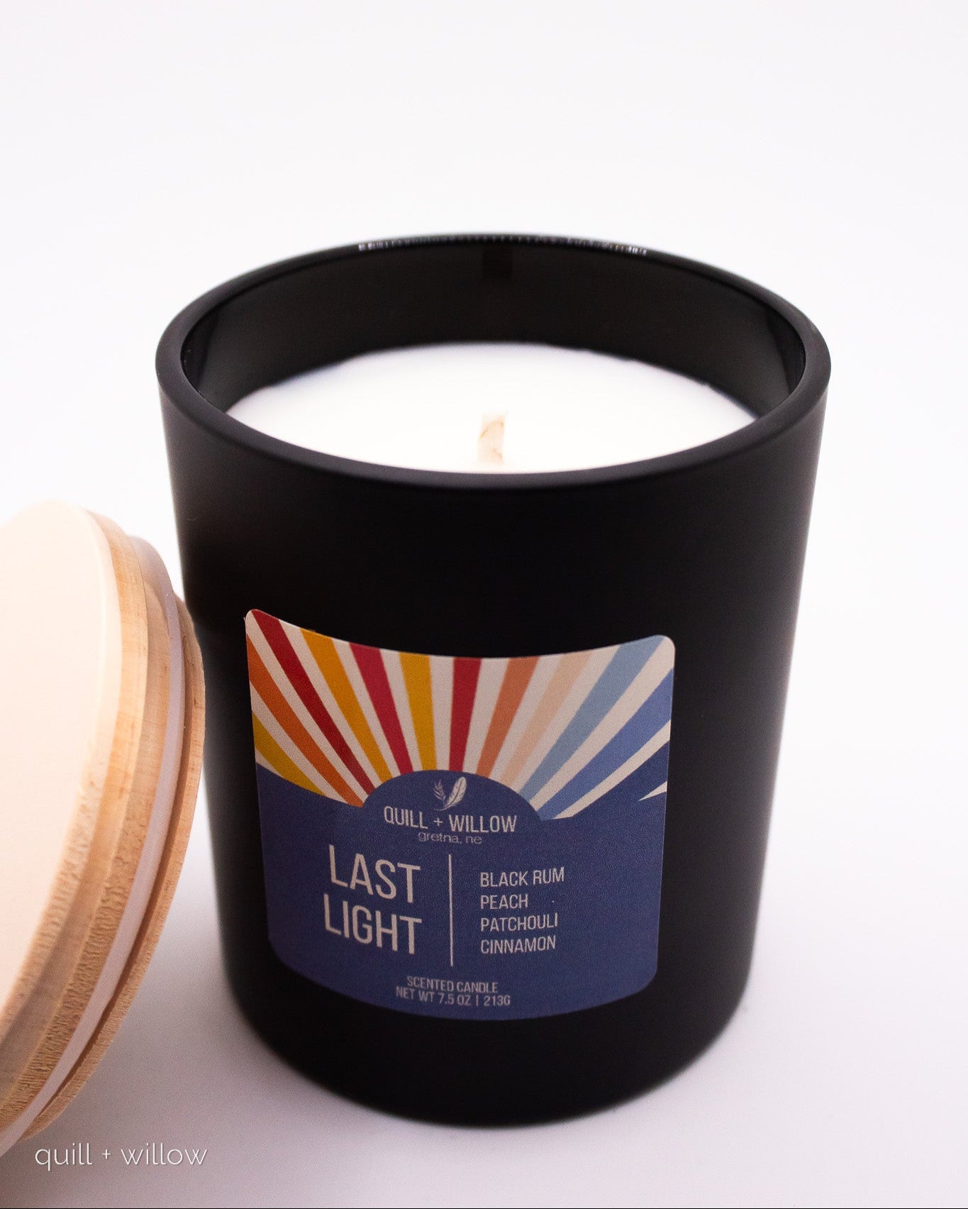 Black candle jar with colorful label on a white background