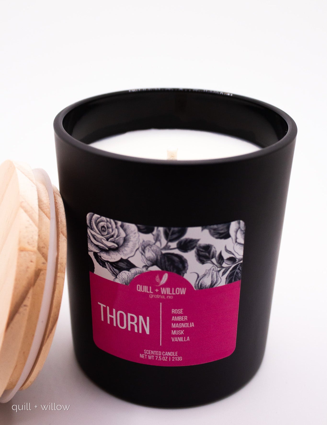 Black candle with floral label on a white background