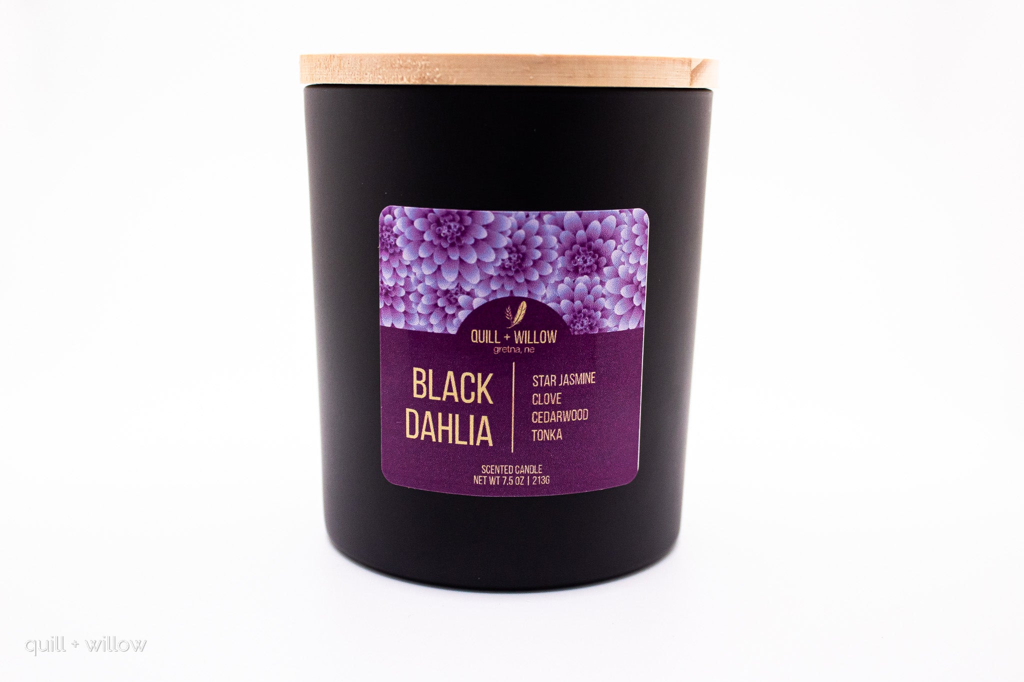 Black candle with a purple label on a white background
