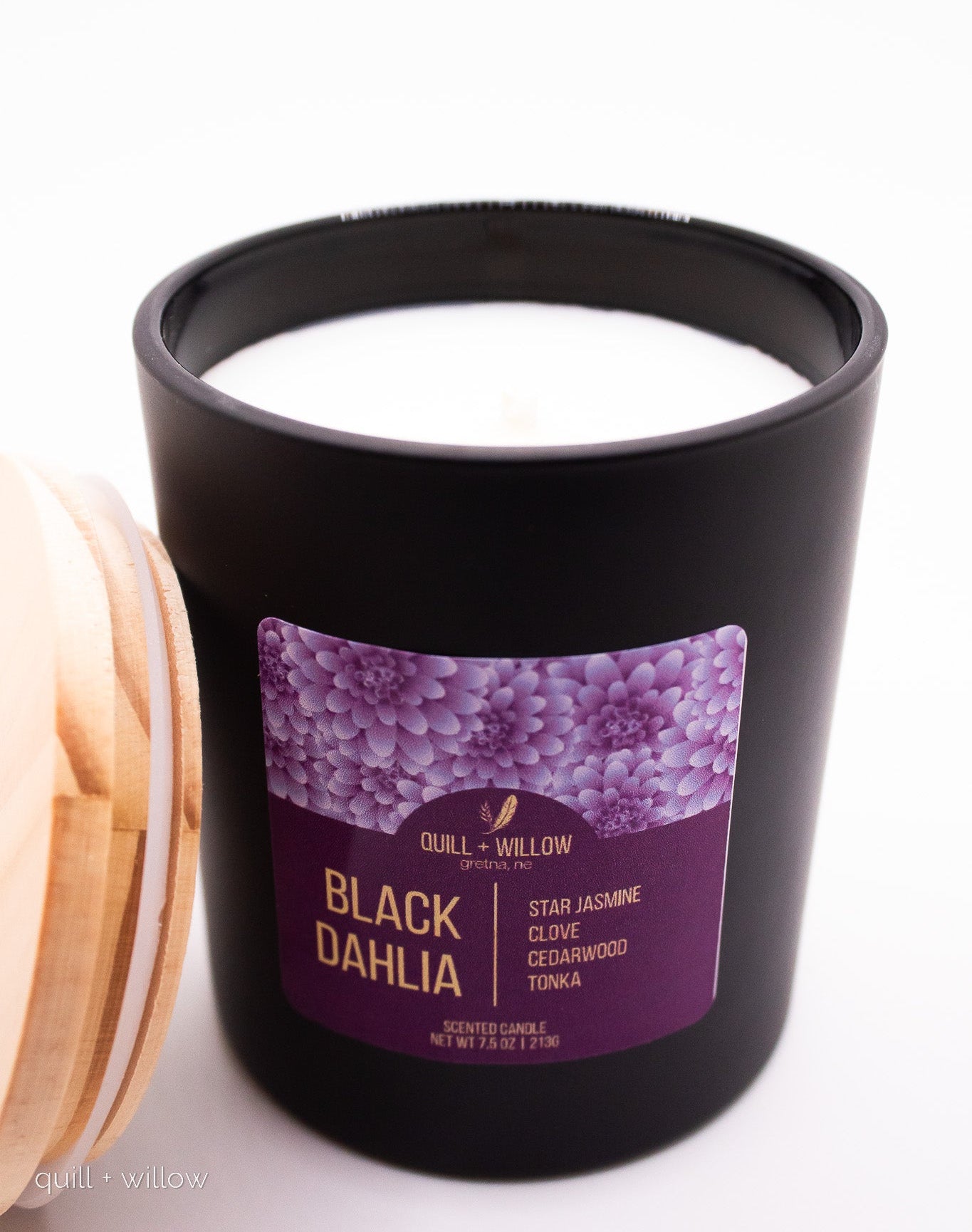 Black candle with a purple label on a white background