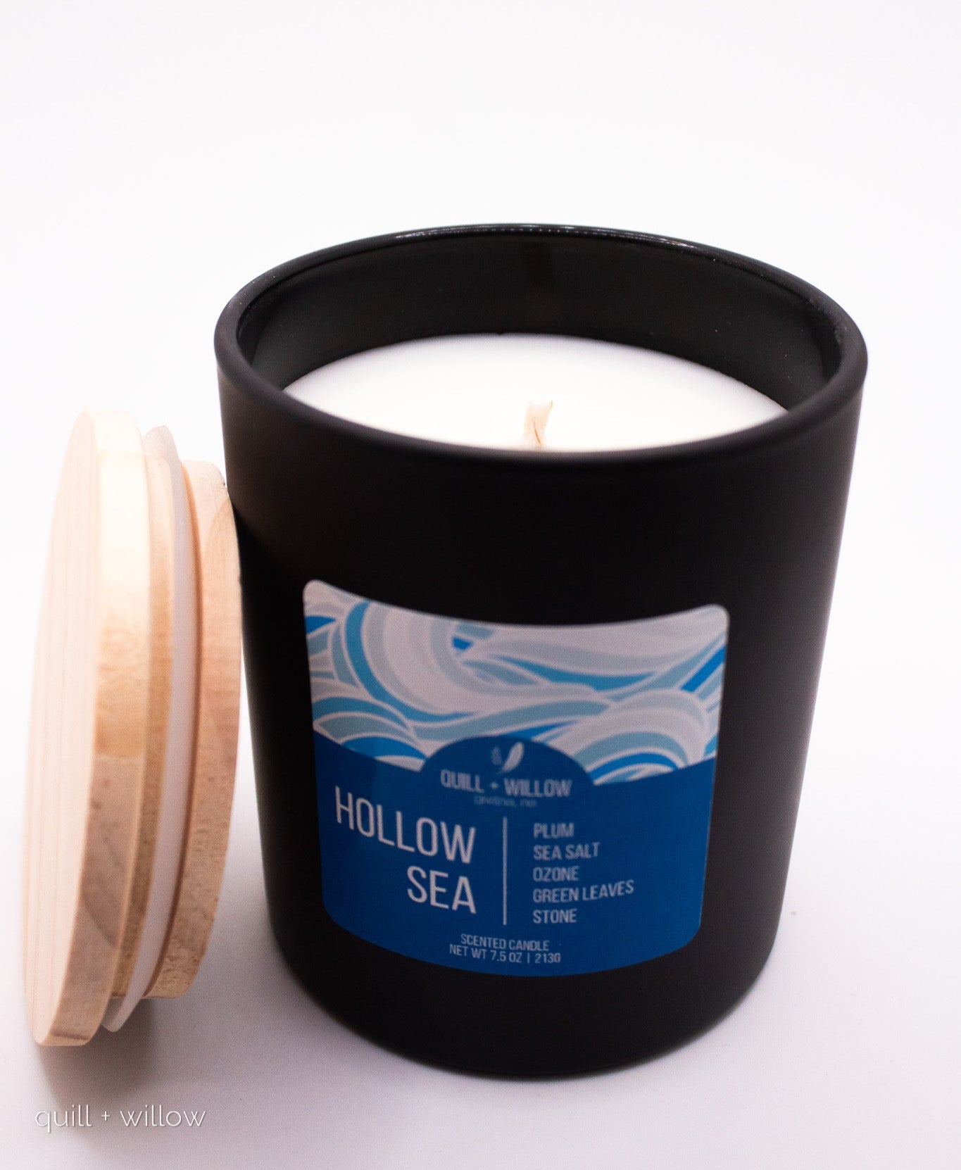Black candle jar with a blue label titled 'Hollow Sea' on a white background