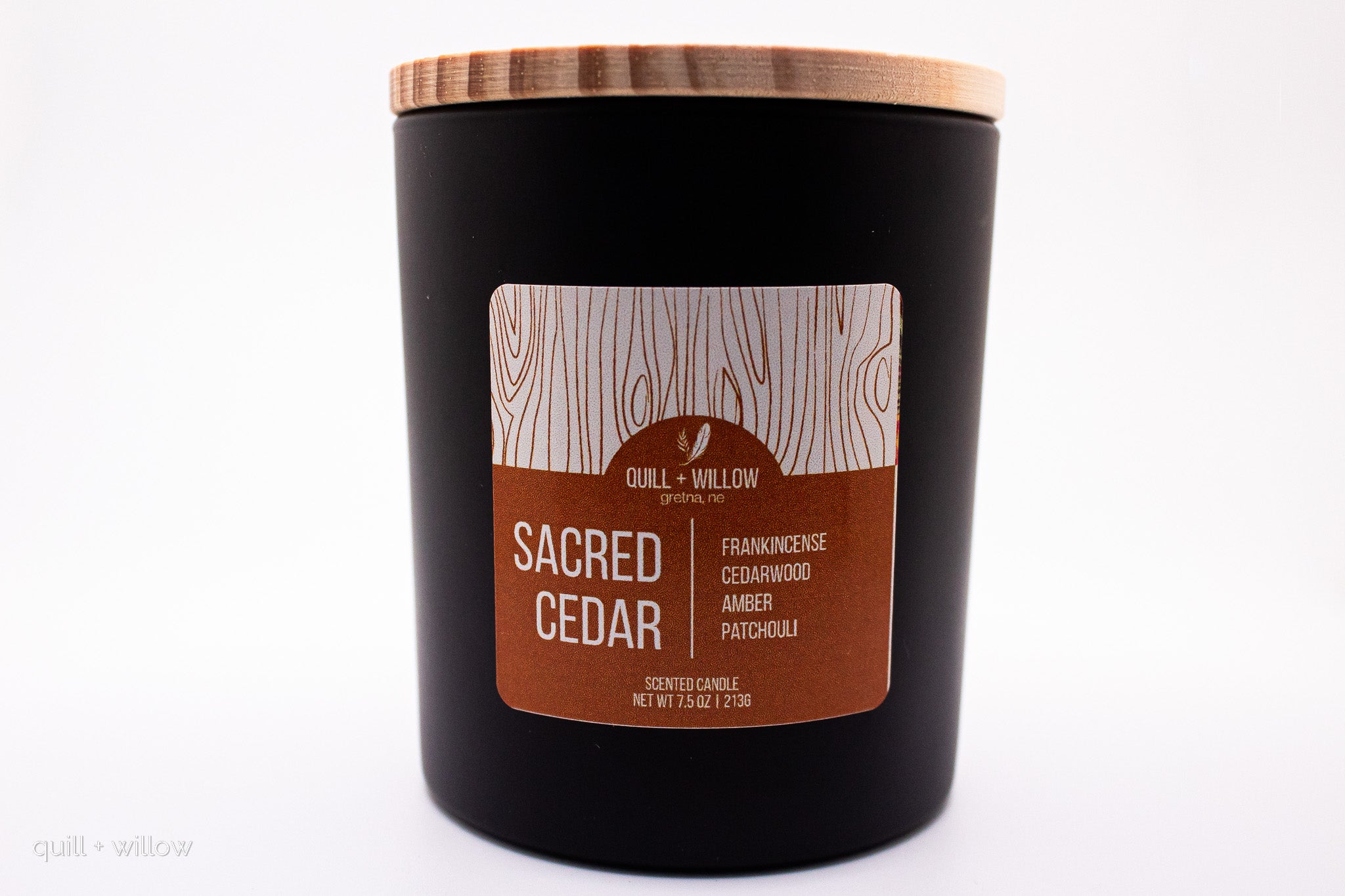 Black candle with a wooden lid and 'Quill & Willow' label on a white background