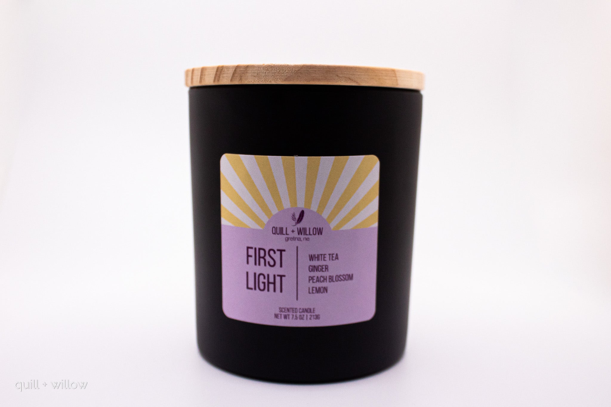 Black candle with a purple label on a white background