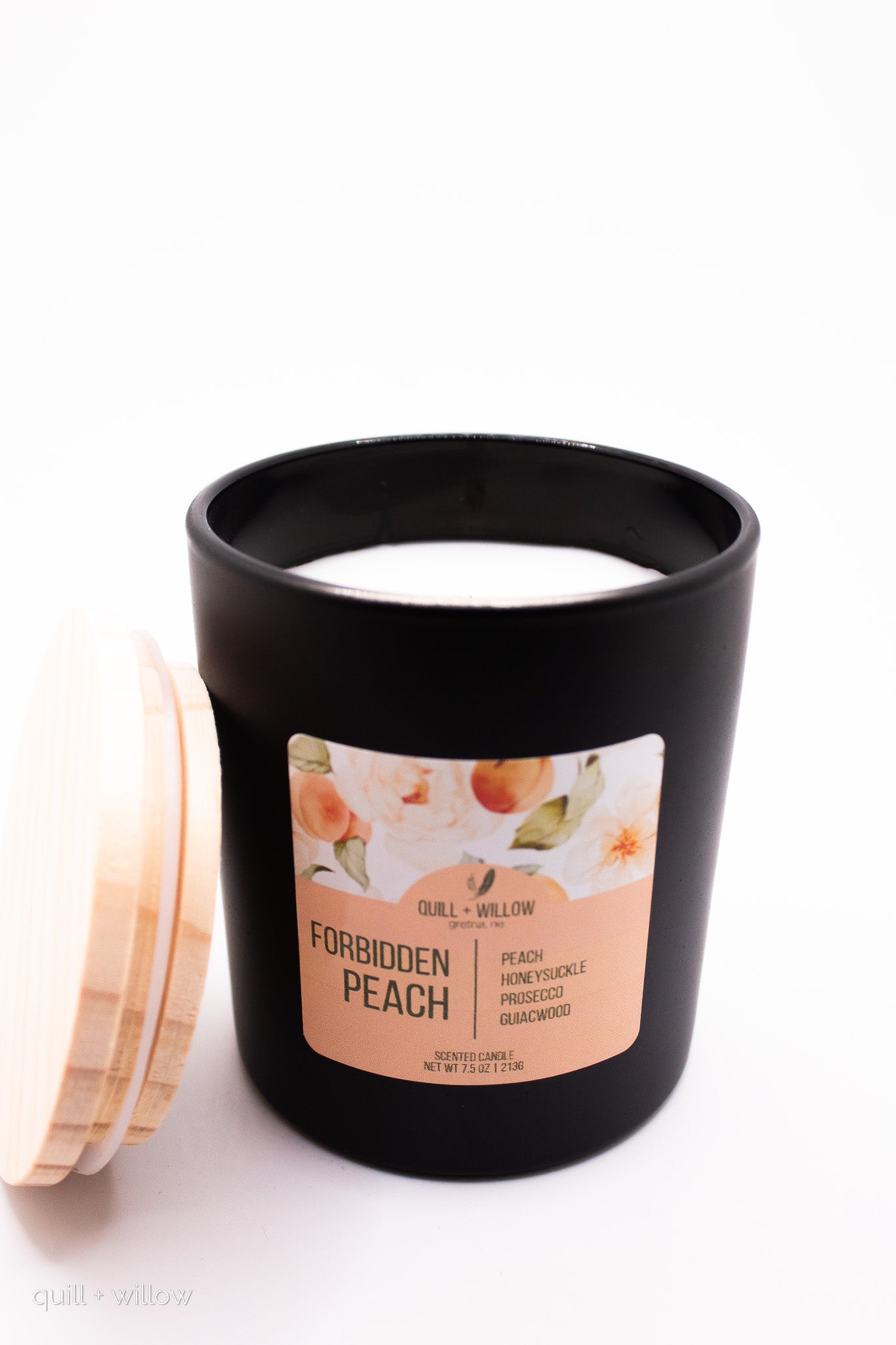 Black candle with 'Forbidden Peach' label on a white background