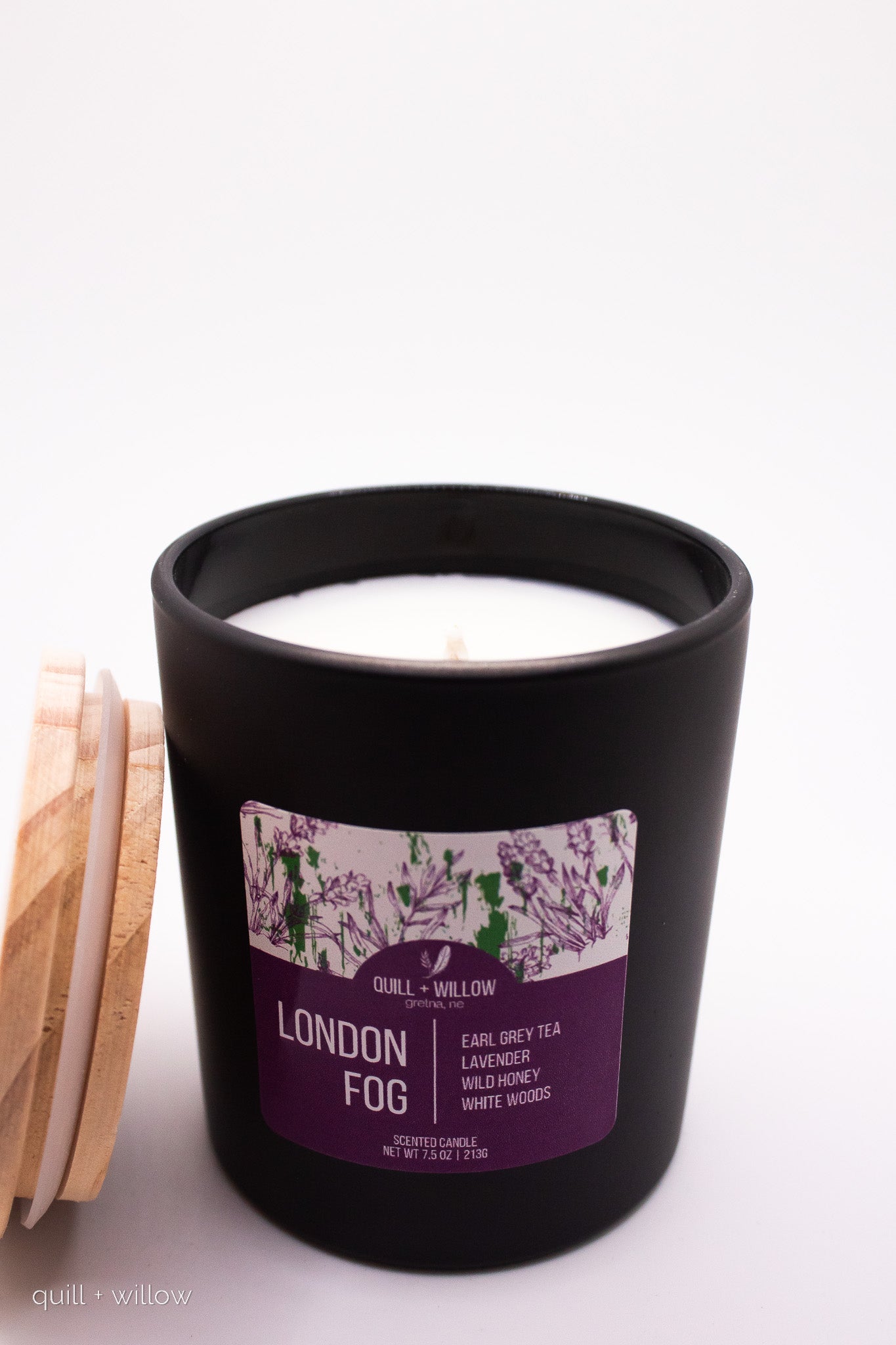 Black candle with a purple label on a white background