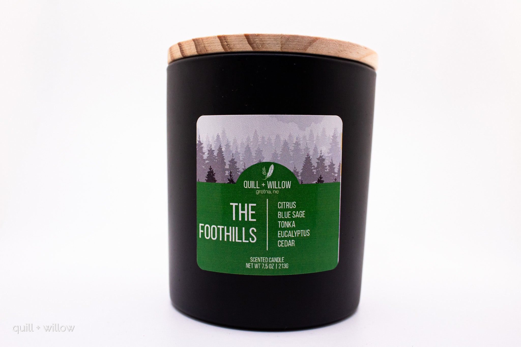 Black candle with a wooden lid and 'The Foothills' label on a white background