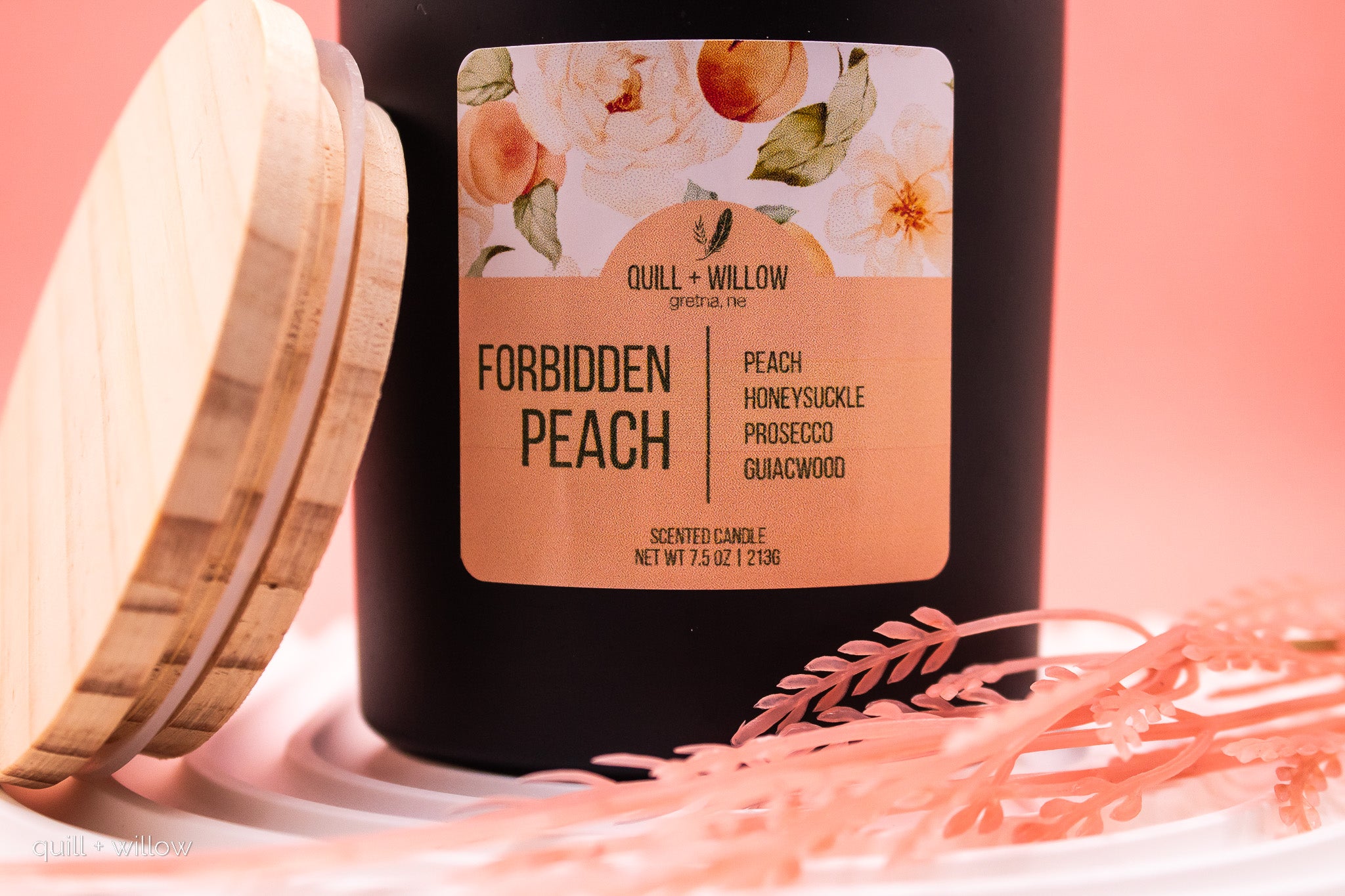 Candle with a floral label on a pink background