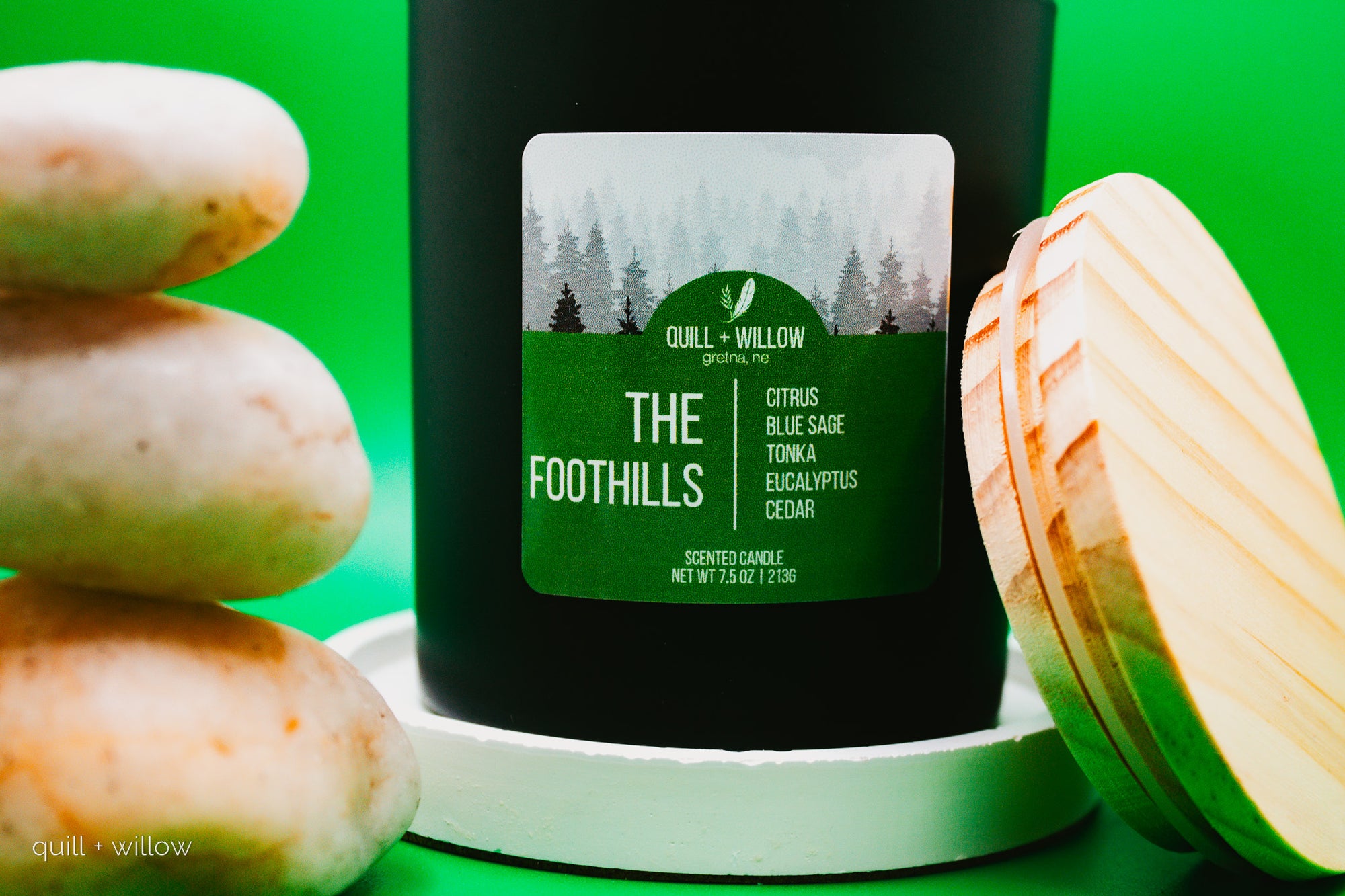 Scented candle labeled 'The Foothills' with a green label on a green background