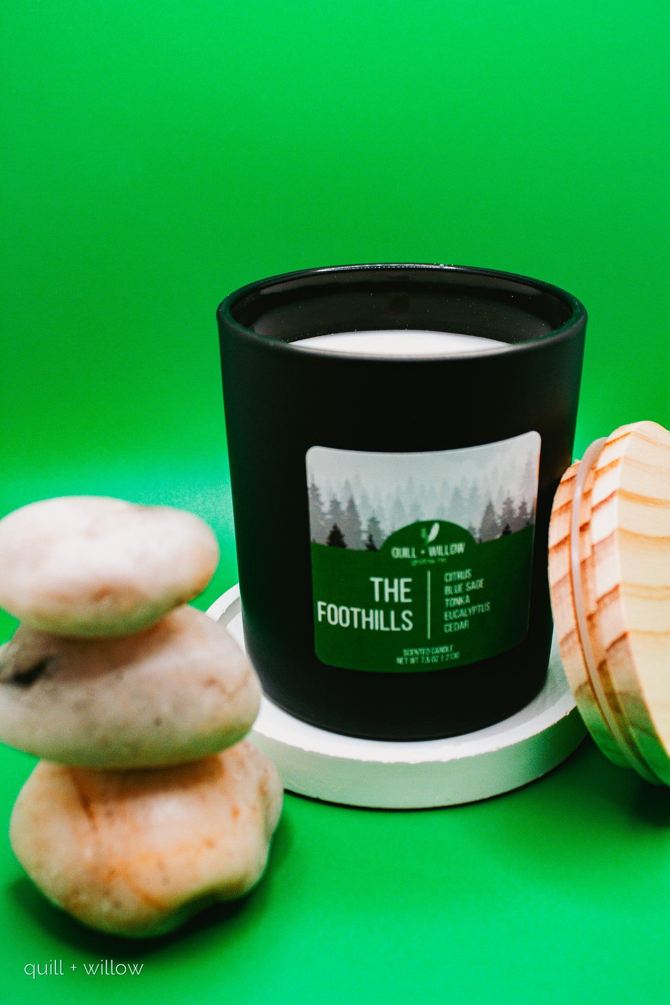 Candle with 'The Foothills' label on a green background